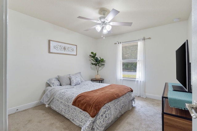 bedroom featuring baseboards, ceiling fan, and light colored carpet