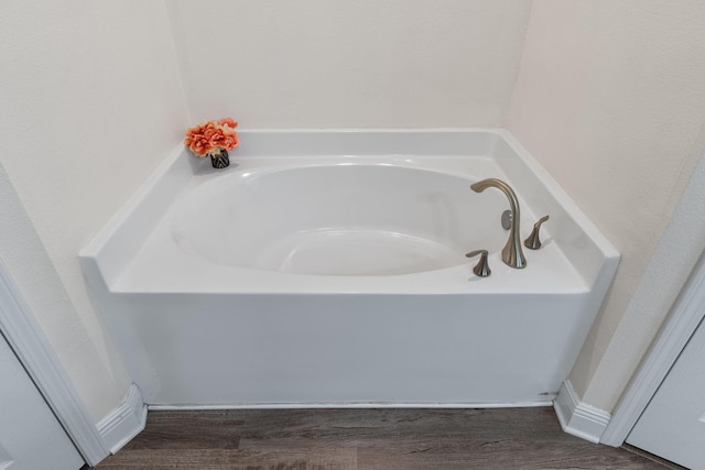 bathroom featuring wood finished floors and a garden tub