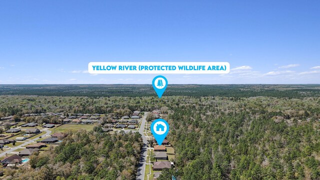 bird's eye view with a wooded view
