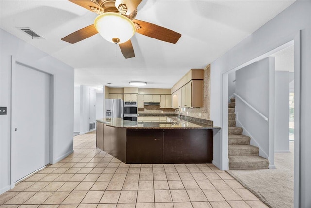 kitchen with visible vents, a peninsula, stainless steel appliances, tasteful backsplash, and light tile patterned floors