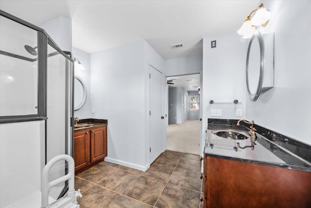 bathroom featuring two vanities, a sink, a stall shower, and visible vents
