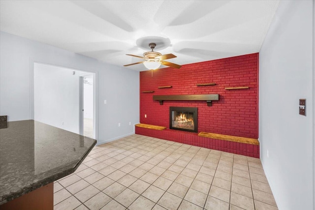 unfurnished living room with a ceiling fan, light tile patterned floors, and a fireplace