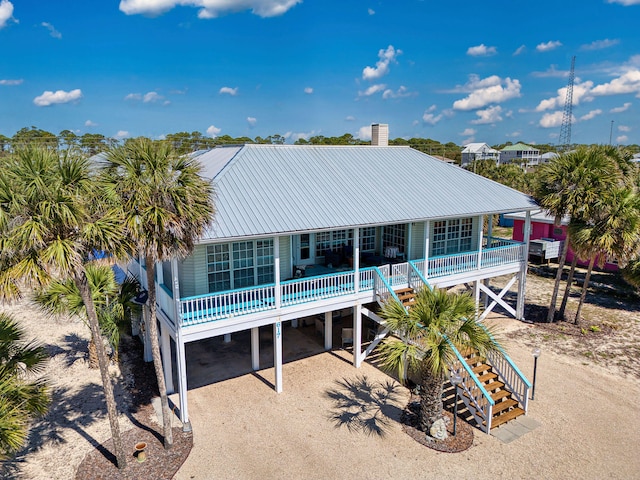 617 E E Gorrie Dr, Saint George Island, FL 32328 - rear view of house with covered porch, a chimney, metal roof, and stairs