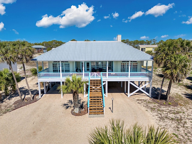 617 E E Gorrie Dr, Saint George Island, FL 32328 - coastal inspired home with stairs, covered porch, metal roof, a carport, and dirt driveway