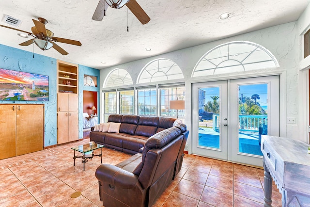 617 E E Gorrie Dr, Saint George Island, FL 32328 - tiled living room with a textured ceiling, visible vents, ceiling fan, built in shelves, and french doors