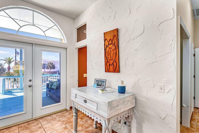 617 E E Gorrie Dr, Saint George Island, FL 32328 - entryway with french doors, light tile patterned floors, a textured wall, a textured ceiling, and visible vents