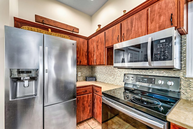 617 E E Gorrie Dr, Saint George Island, FL 32328 - kitchen with light tile patterned flooring, light countertops, decorative backsplash, and stainless steel appliances