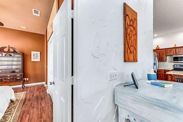 617 E E Gorrie Dr, Saint George Island, FL 32328 - kitchen with light countertops, a textured ceiling, dark wood-style floors, stainless steel appliances, and visible vents