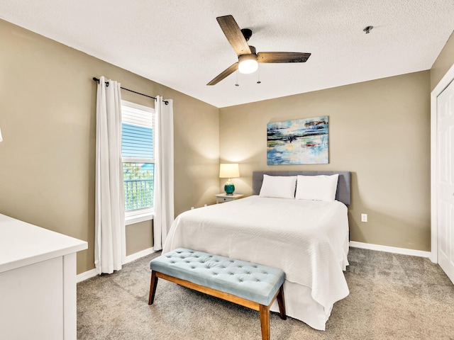 bedroom with light carpet, baseboards, and a textured ceiling