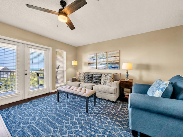 living area featuring ceiling fan, wood finished floors, and a textured ceiling