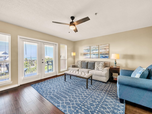 living room featuring a textured ceiling, a ceiling fan, french doors, baseboards, and dark wood-style floors