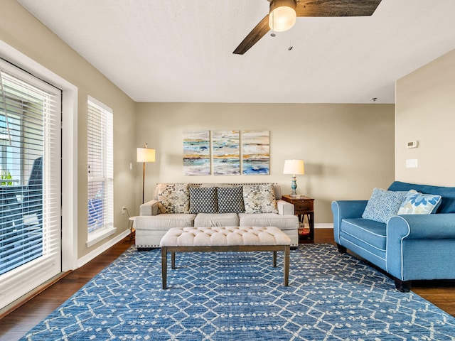 living room with ceiling fan, wood finished floors, and baseboards