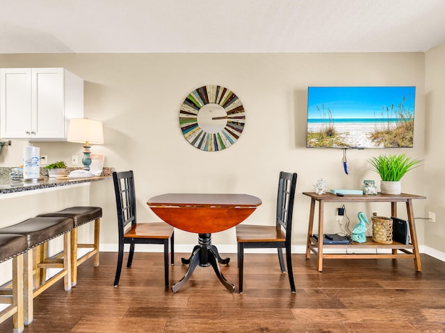dining area with baseboards and wood finished floors