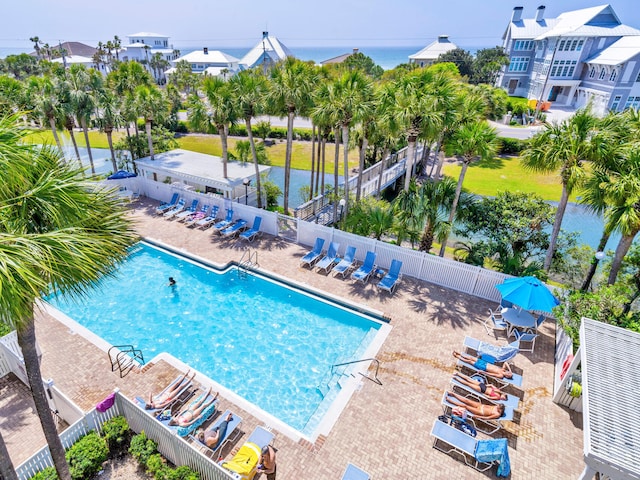 pool with a water view, a patio, and fence