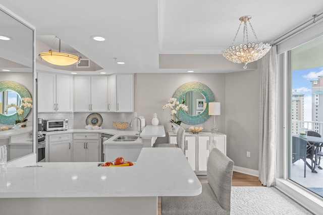 1 Beach Club Dr Unit 1205, Miramar Beach, FL 32550 - kitchen featuring a sink, light wood-type flooring, recessed lighting, a peninsula, and a raised ceiling