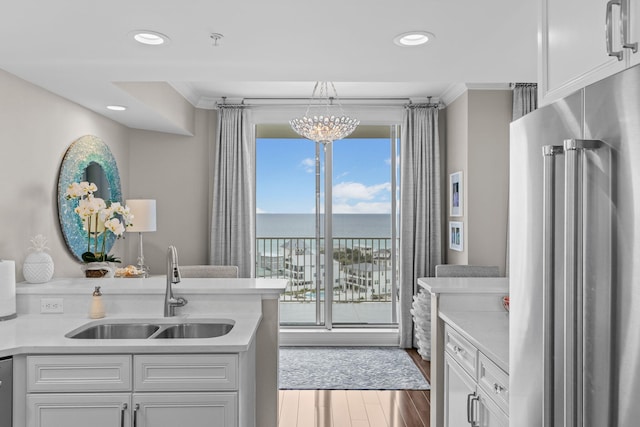 1 Beach Club Dr Unit 1205, Miramar Beach, FL 32550 - kitchen with stainless steel appliances, a sink, light countertops, a chandelier, and ornamental molding