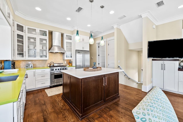 kitchen with dark wood-style flooring, visible vents, wall chimney exhaust hood, and premium appliances