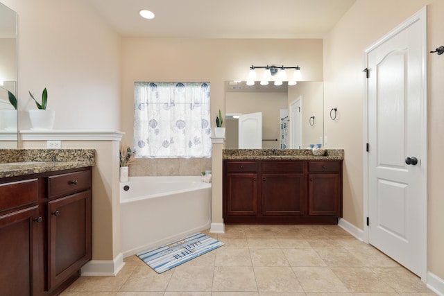 bathroom featuring two vanities, a garden tub, tile patterned flooring, and a sink