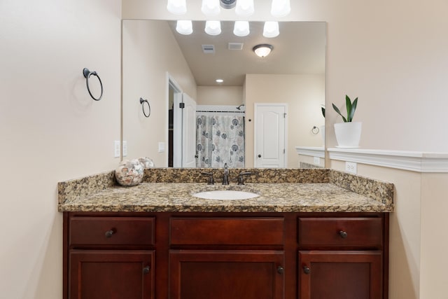 bathroom with curtained shower, visible vents, and vanity