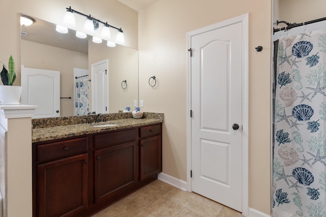 full bathroom featuring a shower with shower curtain, baseboards, tile patterned flooring, and vanity