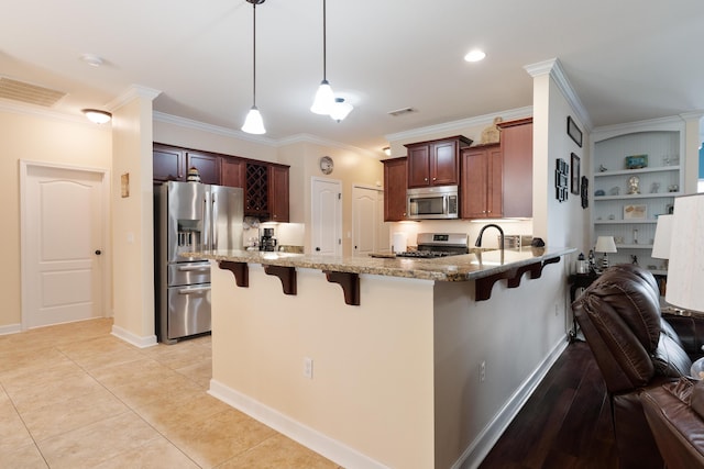 kitchen with a kitchen bar, appliances with stainless steel finishes, light stone countertops, and crown molding