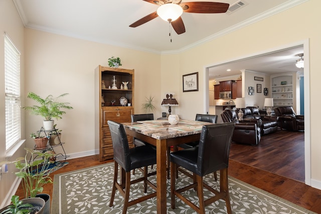 dining area with dark wood-style flooring, a ceiling fan, and ornamental molding