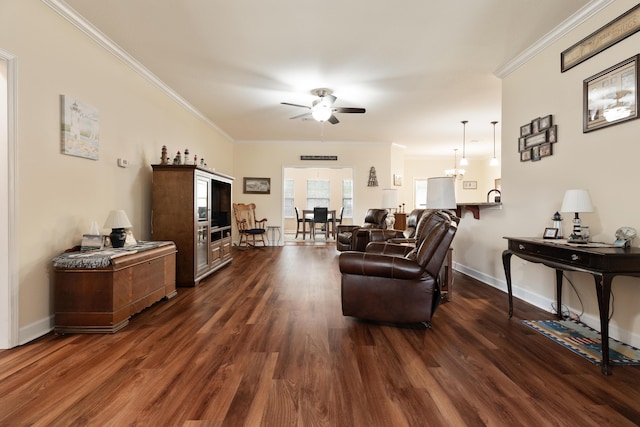 living area with ceiling fan with notable chandelier, baseboards, dark wood-type flooring, and ornamental molding