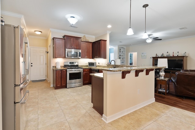 kitchen featuring stainless steel appliances, a breakfast bar, crown molding, a peninsula, and open floor plan