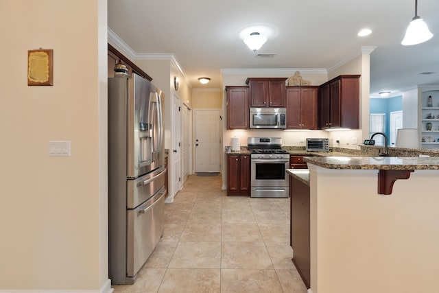 kitchen featuring stainless steel appliances, dark stone countertops, crown molding, a peninsula, and a breakfast bar area