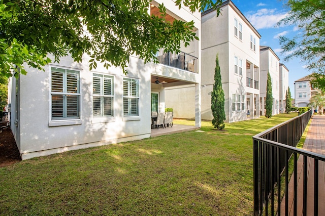 43 Calla Way, Miramar Beach, FL 32550 - rear view of property featuring fence, stucco siding, a balcony, a lawn, and a patio