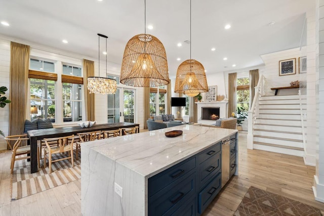 76 Tall Timber Ct, Santa Rosa Beach, FL 32459 - kitchen featuring light wood finished floors, open floor plan, light stone countertops, and a fireplace