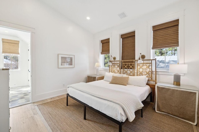 76 Tall Timber Ct, Santa Rosa Beach, FL 32459 - bedroom with multiple windows, visible vents, wood finished floors, and vaulted ceiling