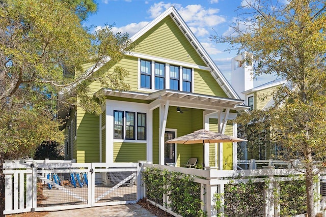 76 Tall Timber Ct, Santa Rosa Beach, FL 32459 - view of front of house with a gate, a fenced front yard, a chimney, and a ceiling fan