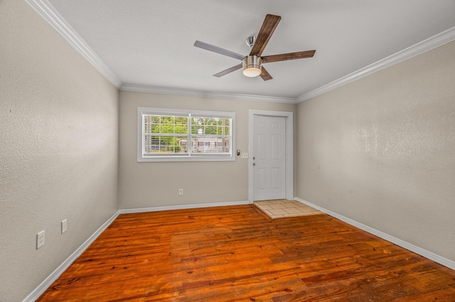 empty room with light wood-style flooring, ornamental molding, ceiling fan, and baseboards