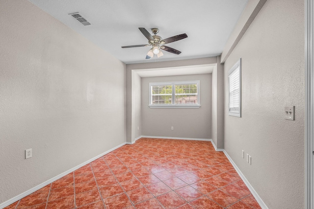 unfurnished room with a ceiling fan, light tile patterned floors, baseboards, and a textured wall
