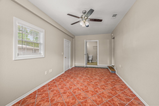 spare room featuring a ceiling fan, baseboards, and tile patterned flooring