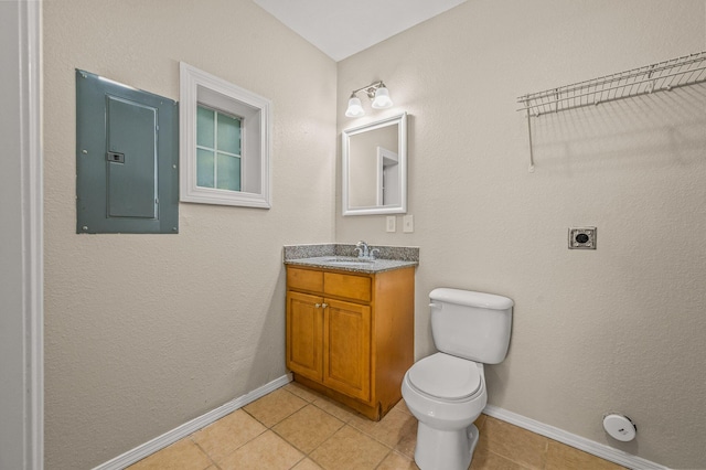 bathroom featuring electric panel, tile patterned flooring, vanity, and toilet