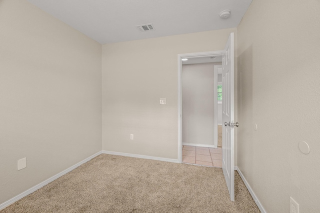 carpeted spare room with a smoke detector and baseboards