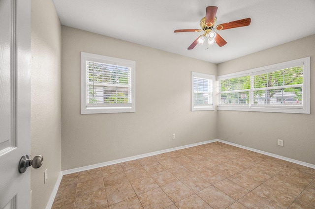 spare room with ceiling fan, baseboards, and light tile patterned floors