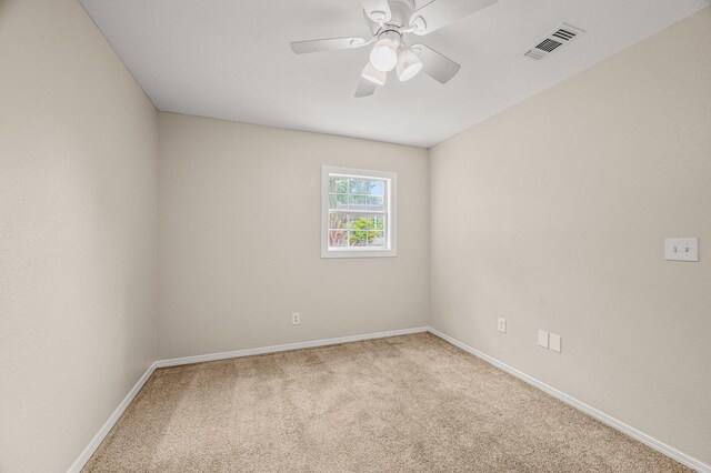 spare room with carpet floors, a ceiling fan, and baseboards