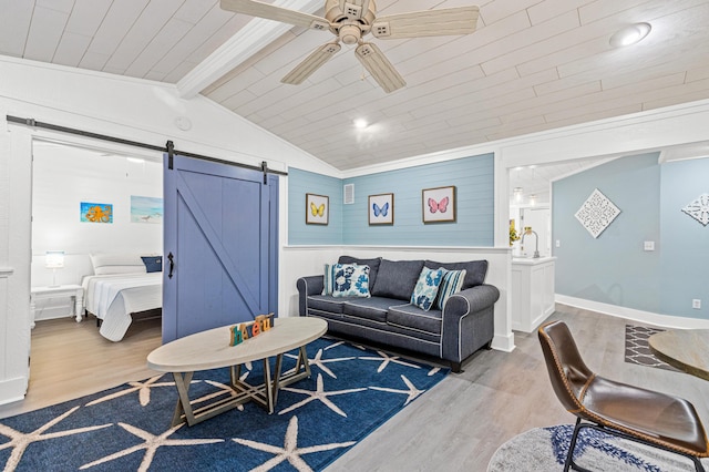living room with a barn door, a ceiling fan, wood finished floors, vaulted ceiling with beams, and wood ceiling
