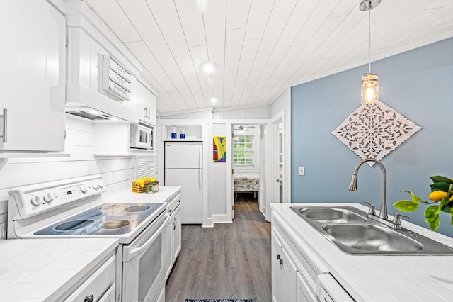 kitchen with tile counters, a sink, white cabinets, white appliances, and dark wood finished floors