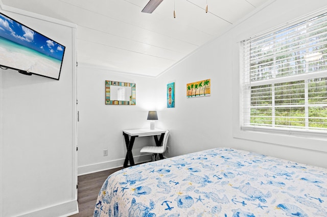 bedroom with lofted ceiling, a ceiling fan, dark wood-type flooring, and baseboards
