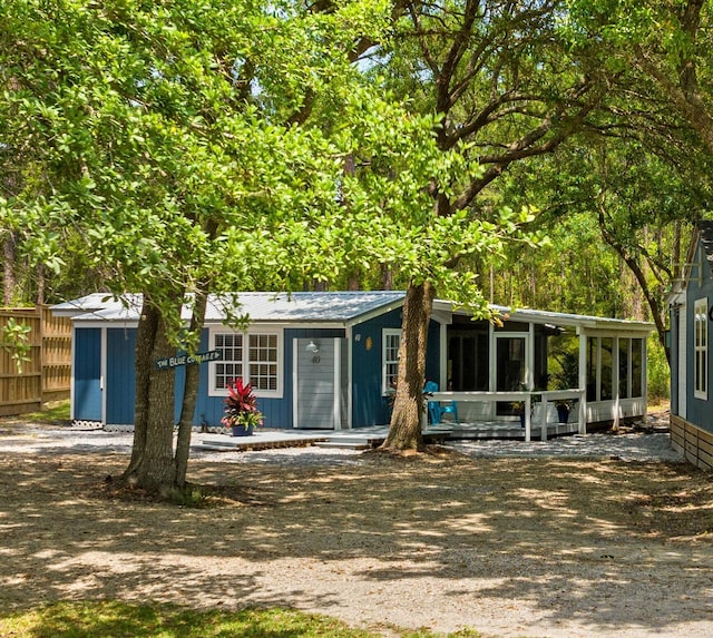 view of front of house with fence and a sunroom