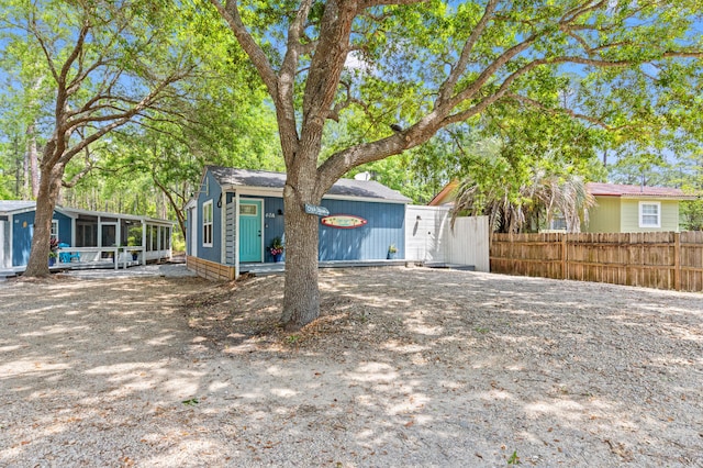 rear view of house with a sunroom and fence