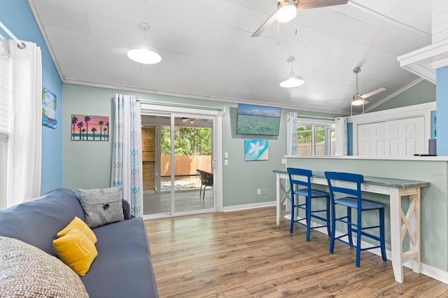 living room with wood finished floors, a ceiling fan, and baseboards