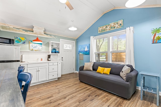 office with a sink, light wood-type flooring, ceiling fan, baseboards, and lofted ceiling