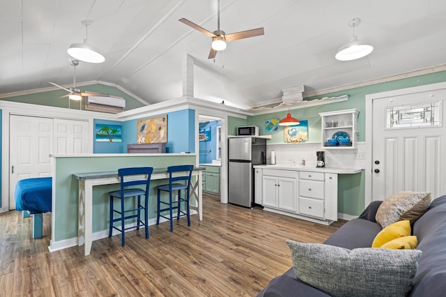 kitchen with open shelves, vaulted ceiling, wood finished floors, freestanding refrigerator, and ceiling fan