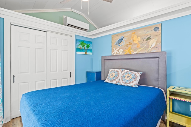bedroom featuring vaulted ceiling, wood finished floors, a wall unit AC, a closet, and ceiling fan