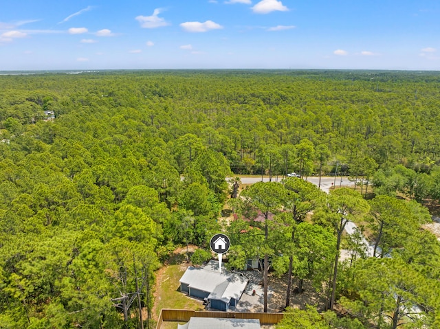 bird's eye view with a wooded view